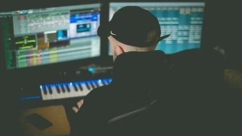 Music producer working at mixing console in professional studio